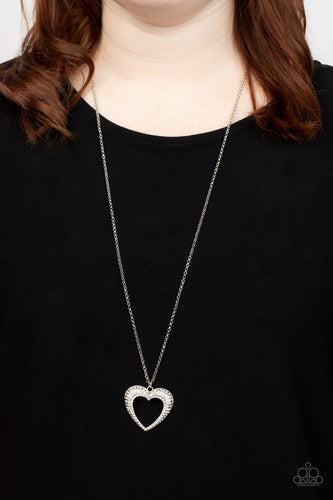 A flared silver heart is encrusted in glassy white rhinestones, resulting in a romantic shimmer at the bottom of an extended silver chain. Features an adjustable clasp closure.  Sold as one individual necklace. Includes one pair of matching earrings.